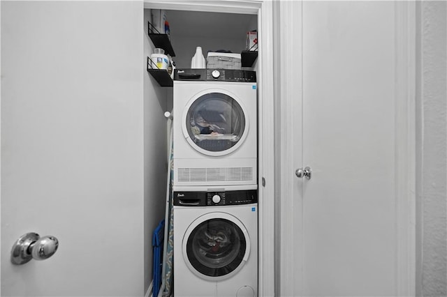 washroom featuring stacked washer and clothes dryer