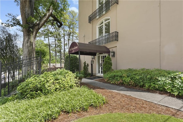 property entrance featuring fence and stucco siding