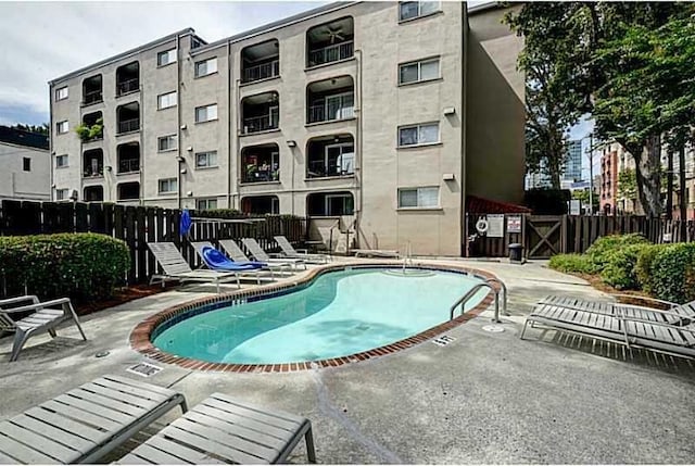 community pool featuring fence and a patio