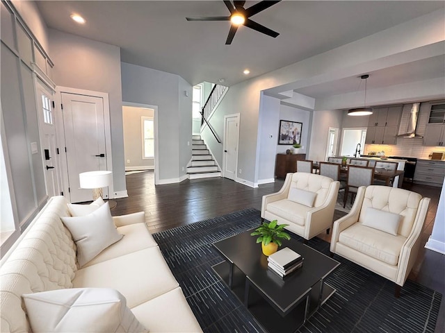 living area with dark wood-style flooring, recessed lighting, stairway, a ceiling fan, and baseboards