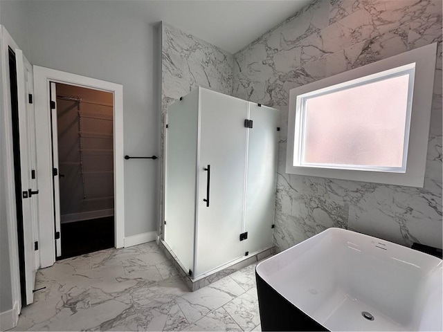 full bathroom featuring a stall shower, a soaking tub, marble finish floor, and a spacious closet