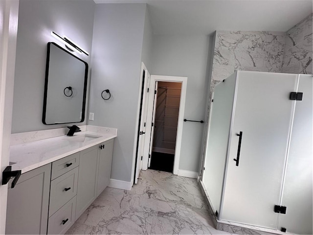 full bath featuring baseboards, marble finish floor, a spacious closet, vanity, and a shower stall