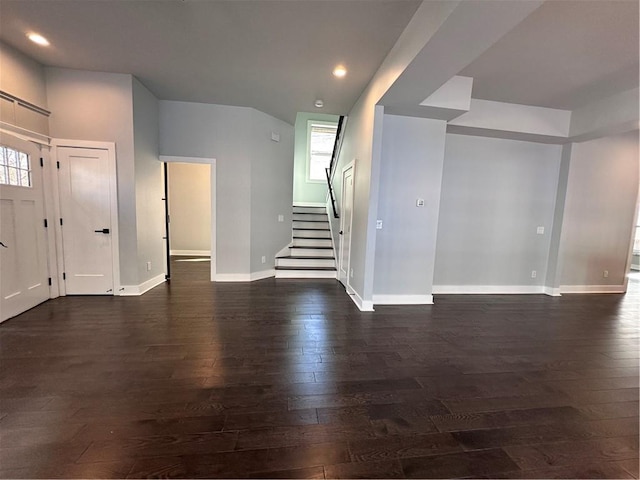 unfurnished living room with dark wood-style floors, baseboards, stairway, and recessed lighting