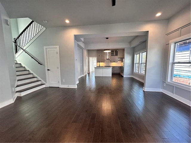 unfurnished living room featuring recessed lighting, dark wood-style flooring, and baseboards