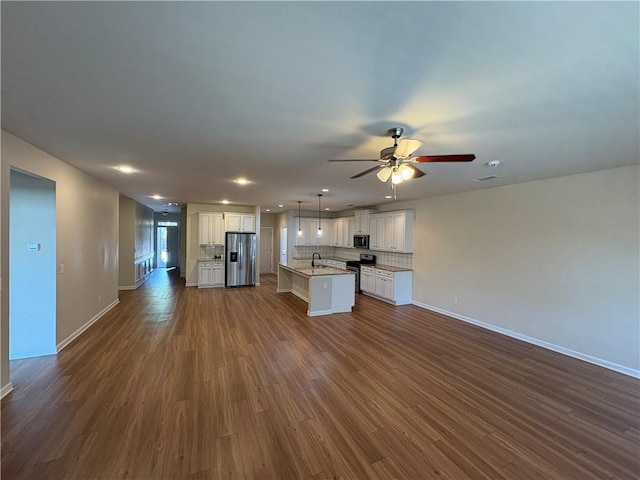 kitchen featuring dark wood-style floors, open floor plan, appliances with stainless steel finishes, and tasteful backsplash