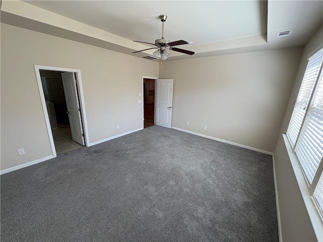 empty room featuring visible vents, baseboards, a tray ceiling, and carpet floors