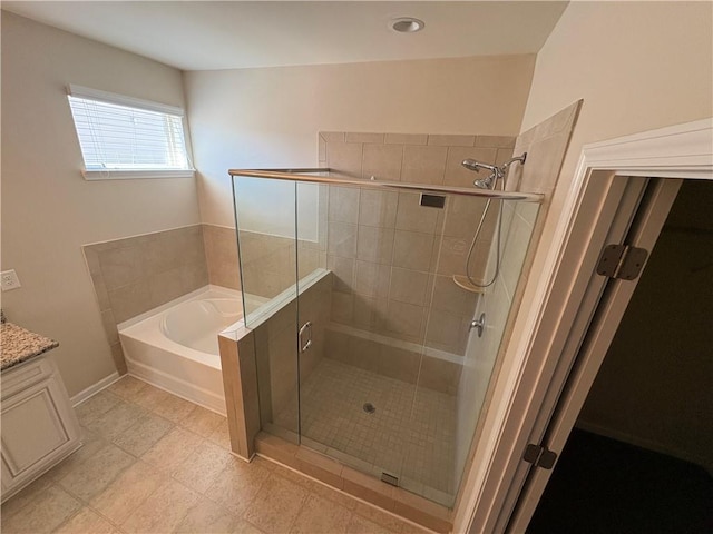 full bath featuring baseboards, vanity, a garden tub, and a shower stall