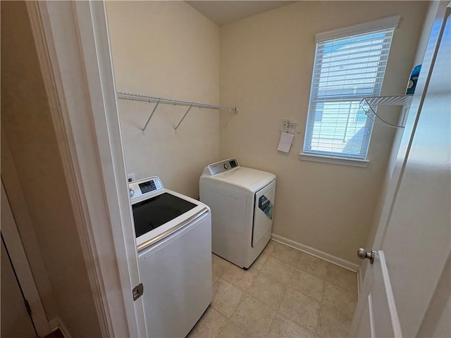 laundry room featuring washing machine and clothes dryer, laundry area, and baseboards