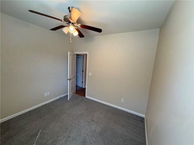 empty room with a ceiling fan, baseboards, and dark colored carpet