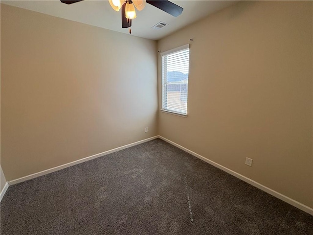 empty room featuring visible vents, dark carpet, a ceiling fan, and baseboards