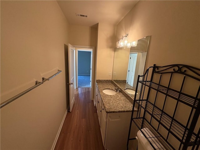 bathroom with visible vents, baseboards, toilet, wood finished floors, and vanity