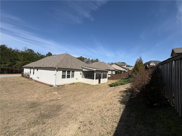 back of property with a fenced backyard and a sunroom