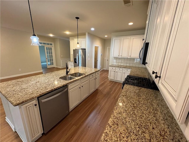 kitchen featuring visible vents, a sink, backsplash, white cabinetry, and appliances with stainless steel finishes