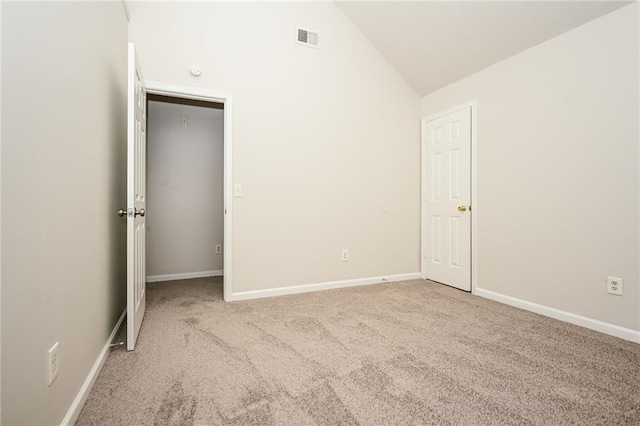 unfurnished bedroom featuring lofted ceiling and light carpet