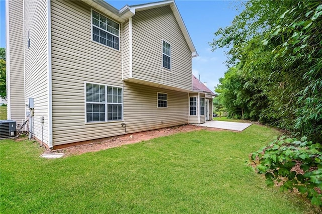 rear view of house with cooling unit, a yard, and a patio area