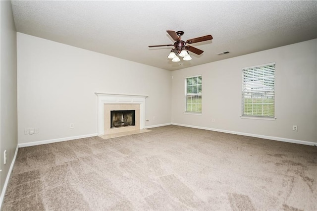 unfurnished living room with light carpet, a textured ceiling, a fireplace, and ceiling fan