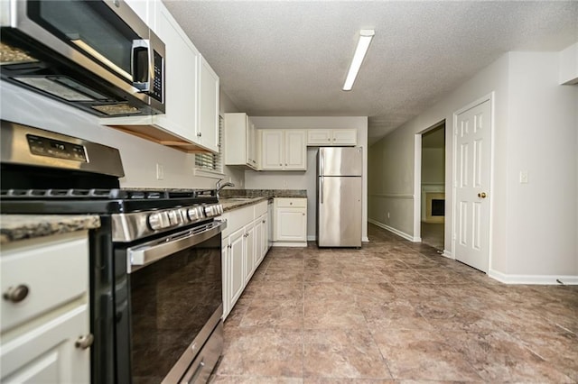 kitchen with white cabinetry, sink, stainless steel appliances, and a textured ceiling