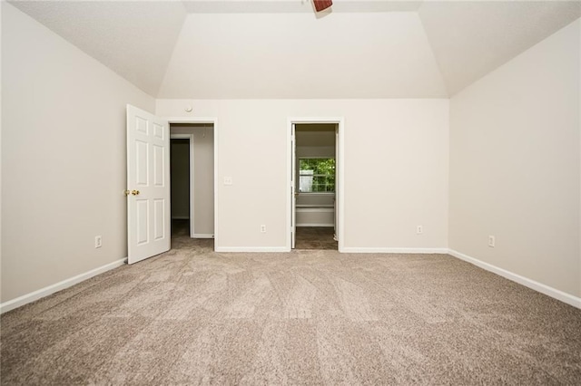 unfurnished bedroom with light colored carpet and lofted ceiling