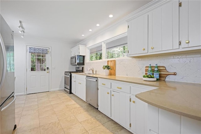 2800 Mornington Dr NW, Atlanta, GA 30327 - kitchen featuring stainless steel appliances, decorative backsplash, light countertops, white cabinetry, and ornamental molding
