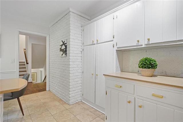 2800 Mornington Dr NW, Atlanta, GA 30327 - kitchen featuring ornamental molding, light countertops, white cabinets, decorative backsplash, and light tile patterned floors