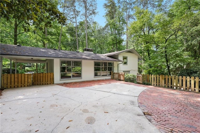 2800 Mornington Dr NW, Atlanta, GA 30327 - rear view of property with stucco siding, driveway, and view of wooded area