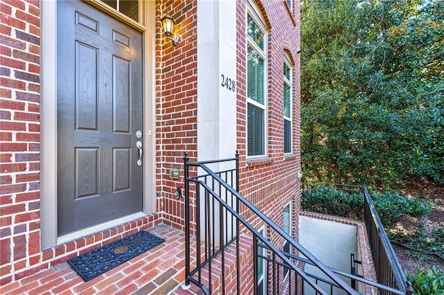 view of exterior entry featuring brick siding