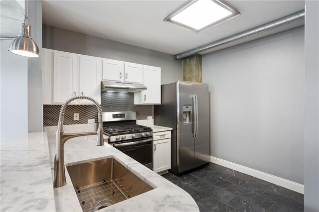 115 W Peachtree Pl NW Unit 602, Atlanta, GA 30313 - kitchen with stainless steel appliances, under cabinet range hood, light stone counters, and white cabinets