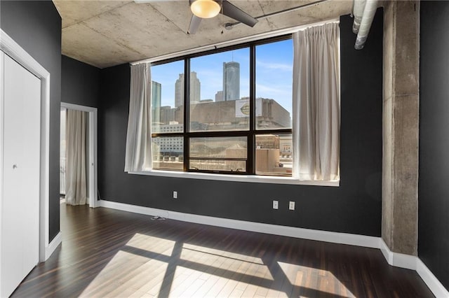 115 W Peachtree Pl NW Unit 602, Atlanta, GA 30313 - empty room featuring wood finished floors, a skyline view, ceiling fan, and baseboards