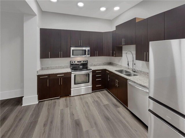 kitchen featuring sink, light wood-type flooring, dark brown cabinetry, and stainless steel appliances