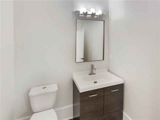 bathroom featuring a notable chandelier, toilet, and vanity