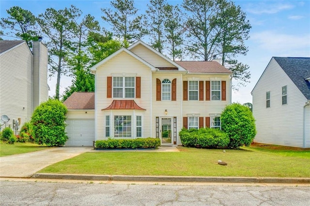 colonial home featuring a garage, a front lawn, and driveway