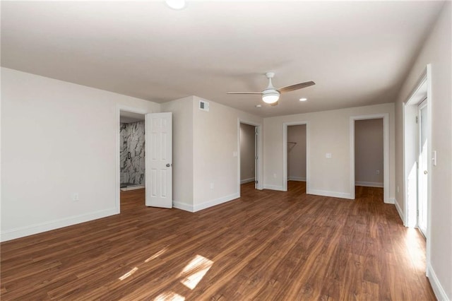 unfurnished bedroom with dark wood-type flooring, a walk in closet, ceiling fan, and a closet