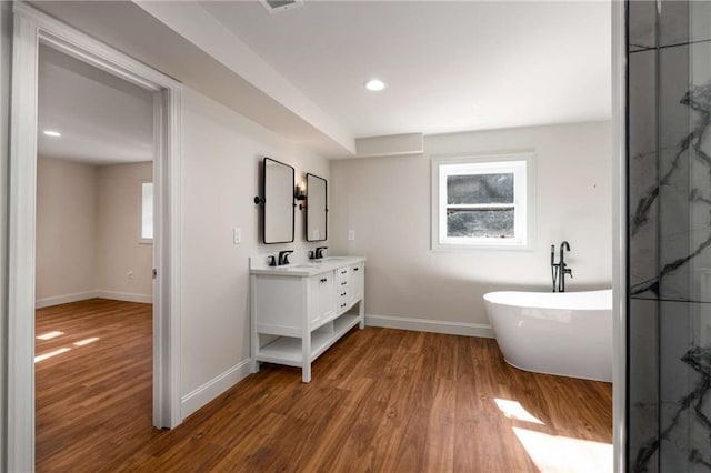 bathroom with vanity, a bathing tub, and hardwood / wood-style floors