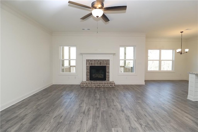 unfurnished living room featuring ornamental molding, dark hardwood / wood-style floors, a brick fireplace, and a wealth of natural light