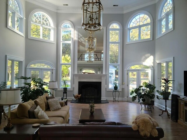 tiled entryway with a chandelier, a high ceiling, and ornamental molding