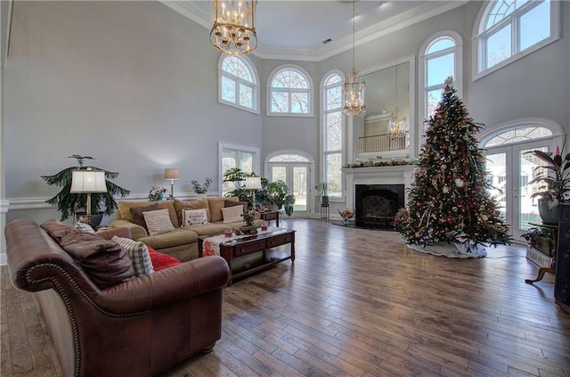 living room with hardwood / wood-style flooring, plenty of natural light, a high ceiling, and an inviting chandelier