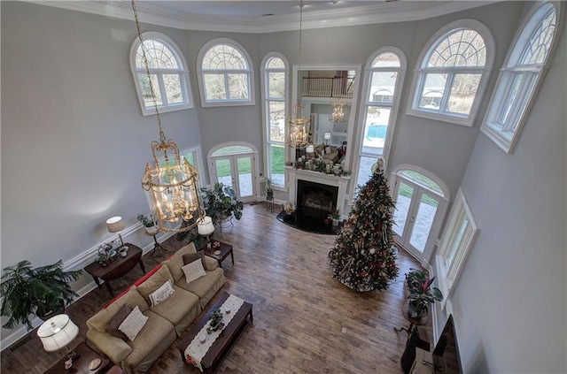 living room with plenty of natural light, crown molding, and a high ceiling