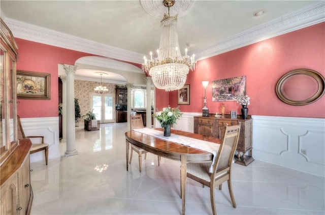 dining room featuring a chandelier, french doors, crown molding, and decorative columns