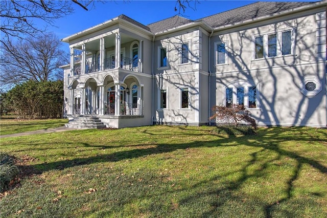 view of front facade featuring a balcony and a front lawn