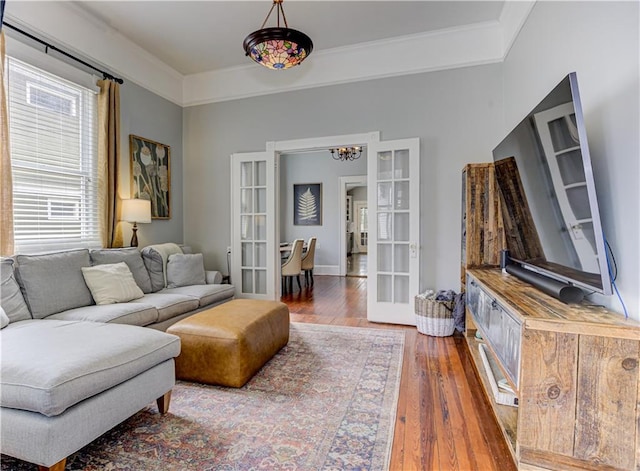 living room featuring ornamental molding, hardwood / wood-style floors, and french doors