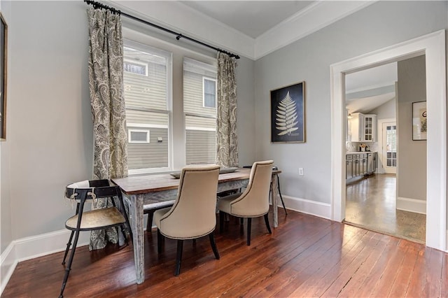 dining room featuring lofted ceiling, baseboards, and hardwood / wood-style floors