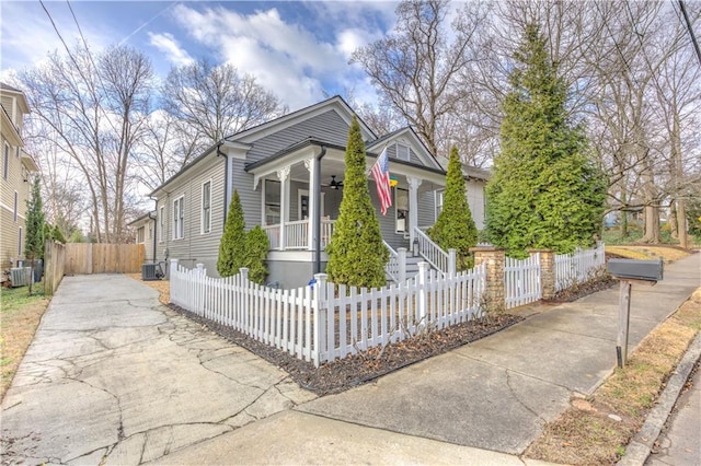 view of front of home featuring a porch, central AC, ceiling fan, and a fenced front yard