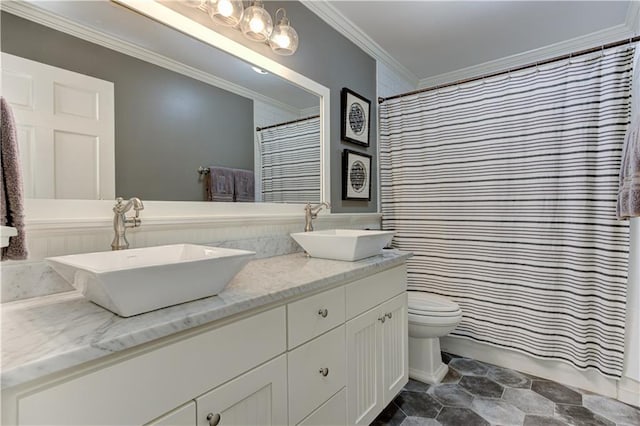 full bath featuring crown molding, a sink, toilet, and double vanity