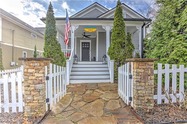 view of front of house with covered porch, a fenced front yard, and a gate