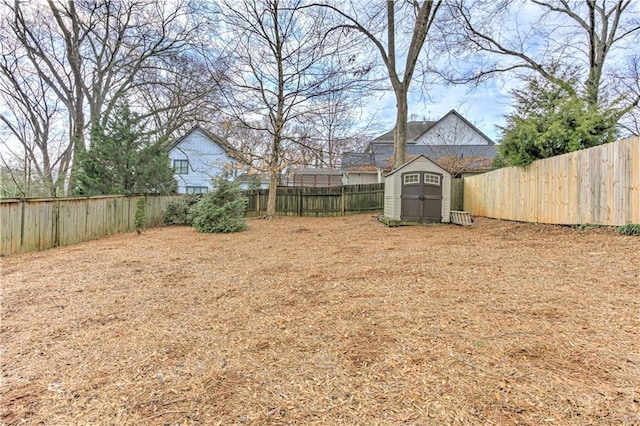 view of yard with a fenced backyard, an outdoor structure, and a shed