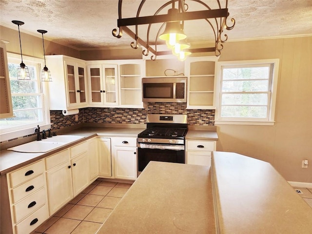 kitchen featuring decorative light fixtures, stainless steel appliances, a healthy amount of sunlight, and sink