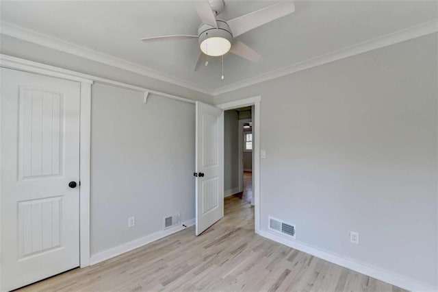 unfurnished bedroom featuring ceiling fan, ornamental molding, a closet, and light wood-type flooring