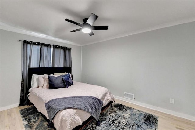 bedroom with ornamental molding, ceiling fan, and light hardwood / wood-style flooring