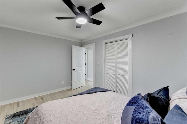 bedroom with light hardwood / wood-style flooring, ornamental molding, a closet, and ceiling fan