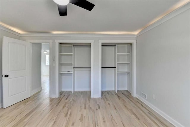 unfurnished bedroom with multiple closets, ceiling fan, and light wood-type flooring